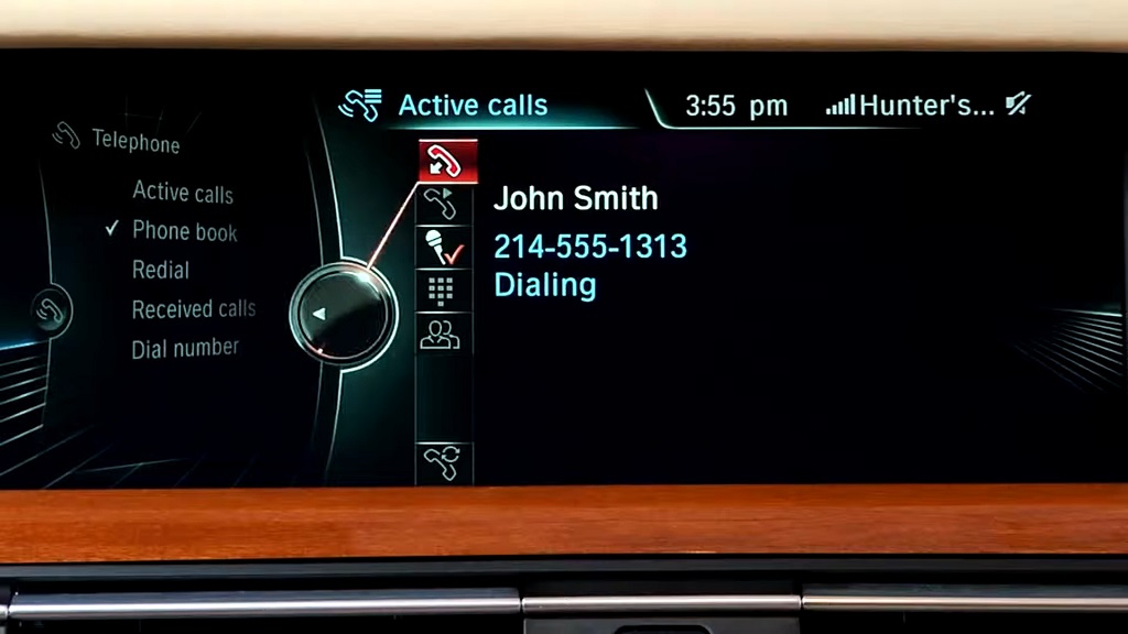 iDrive display showing an active Bluetooth phone call in progress, dialing a contact named John Smith