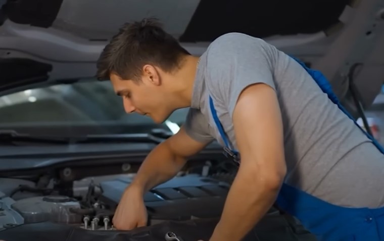 Car mechanic fixing car AC under the hood